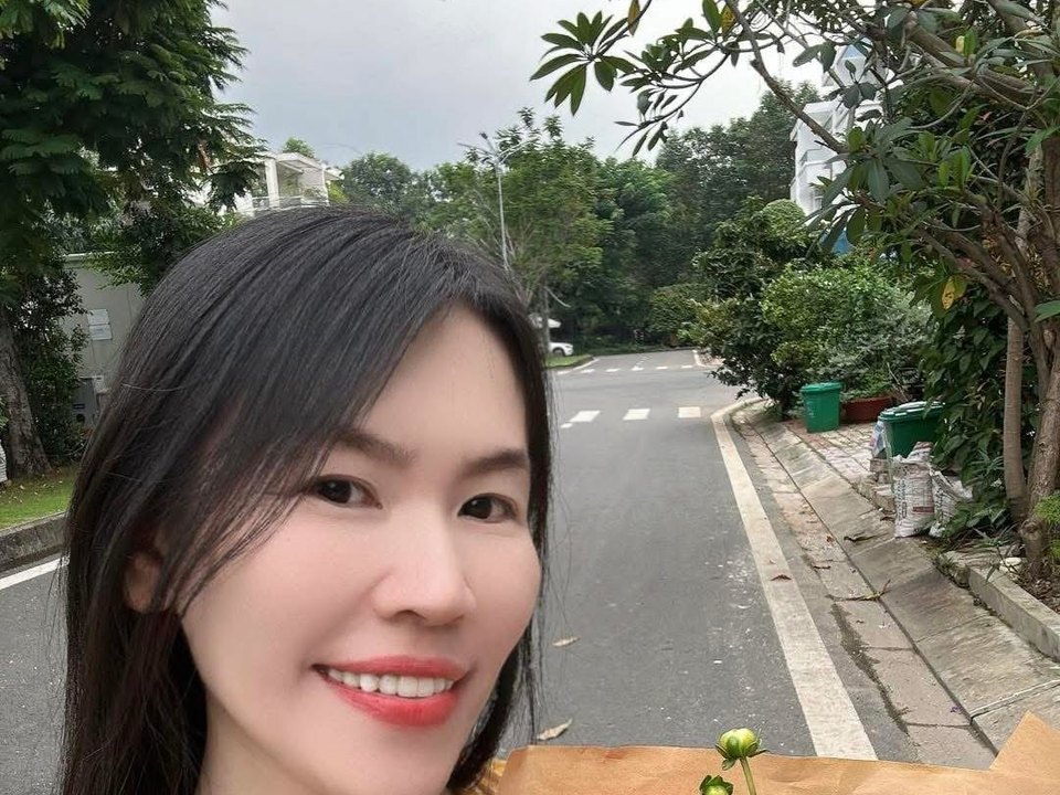 Hồ Trần Phương Nga cầm hoa trên một con phố